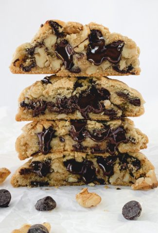 Artistic photo of a stack of cookies cut open with melted chocolate dripping down them