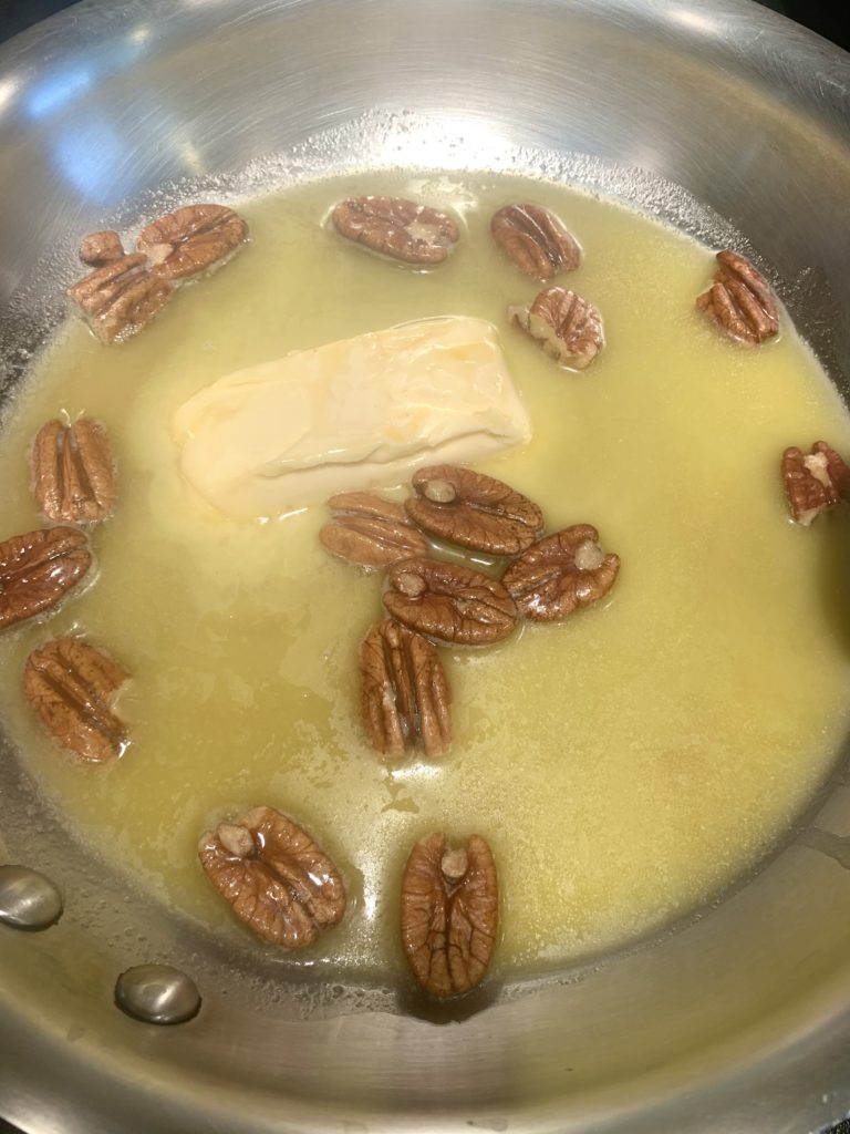 Butter and pecans melting in a pan