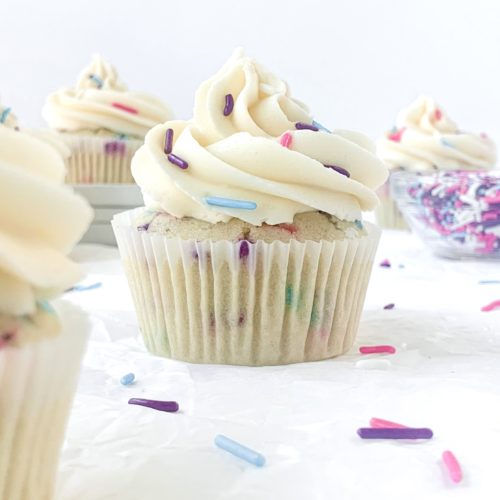 Artistic shot of cupcakes with sprinkles scattered around them