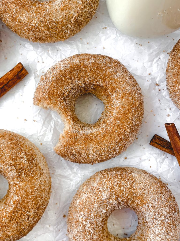A few donuts on a white background, one with a bite taken out