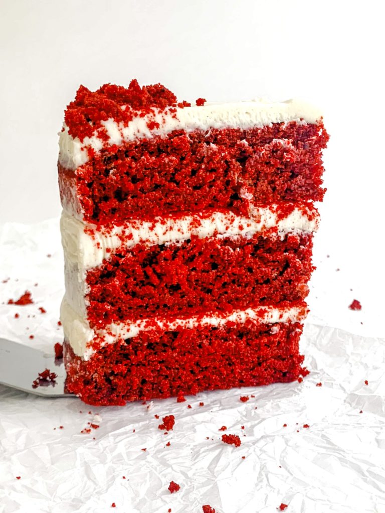 Photo of a 3-layer red velvet cake, standing up on a white background