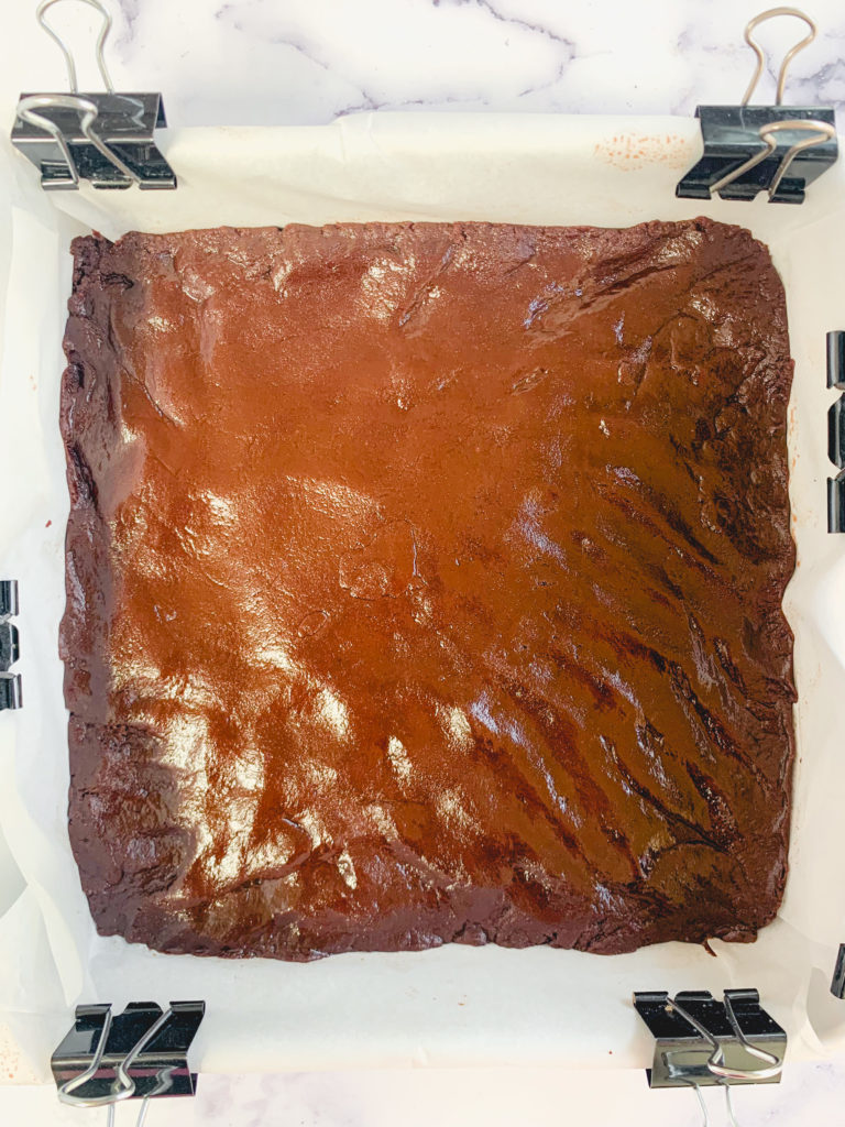 Brownie layer pressed into the pan, unbaked