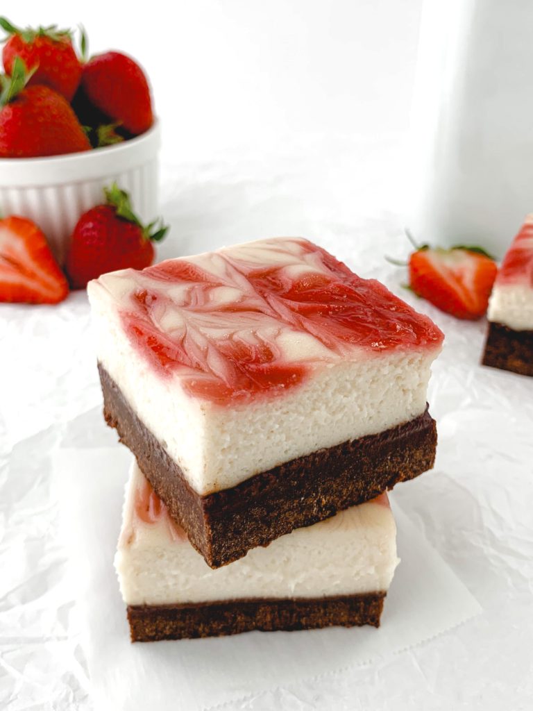 Photo of two bars on top of one another with a bowl of strawberries in the background