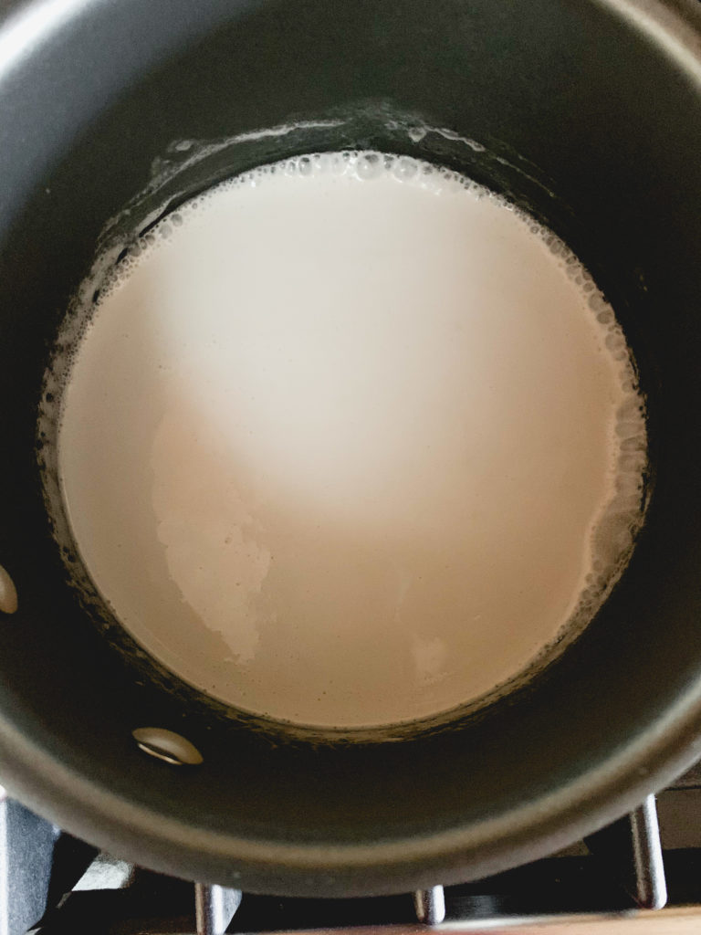 Coconut cream in a small pot - about to boil