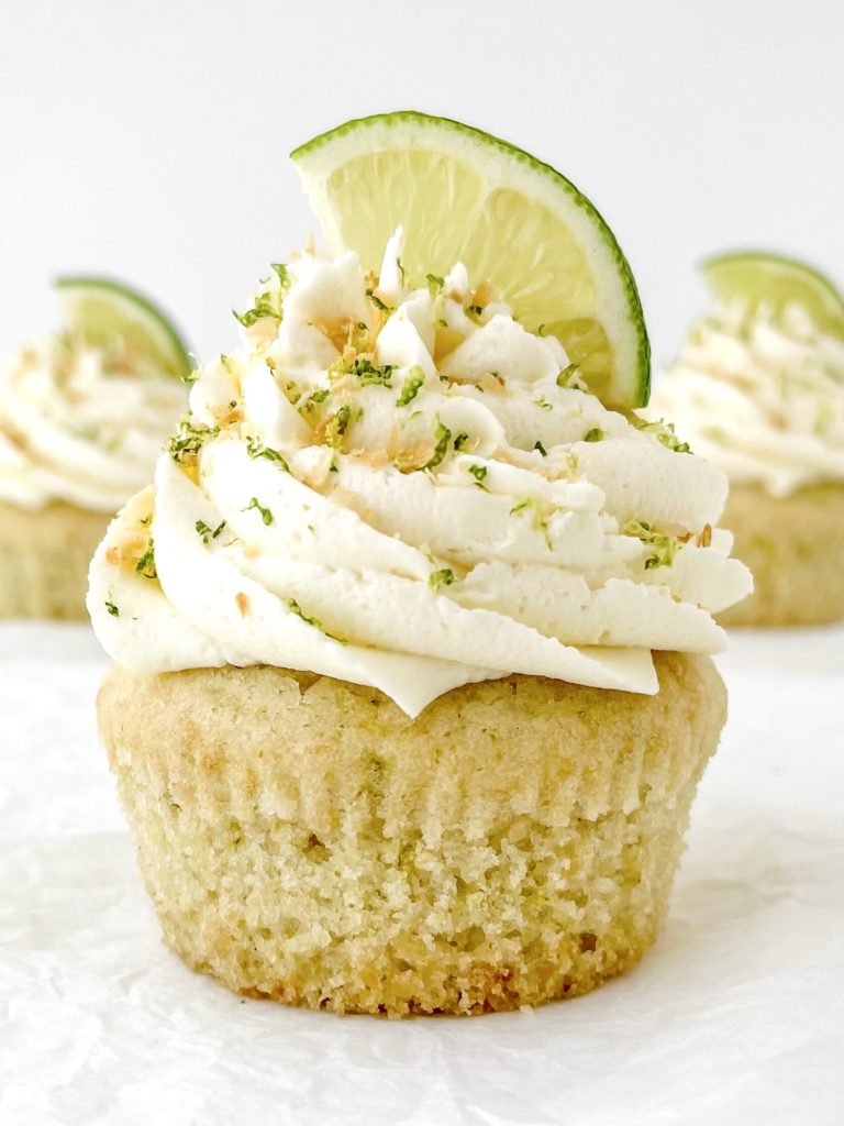 Vegan Coconut Lime Cupcakes one close up cupcake topped with a frosting swirl and lime wedge
