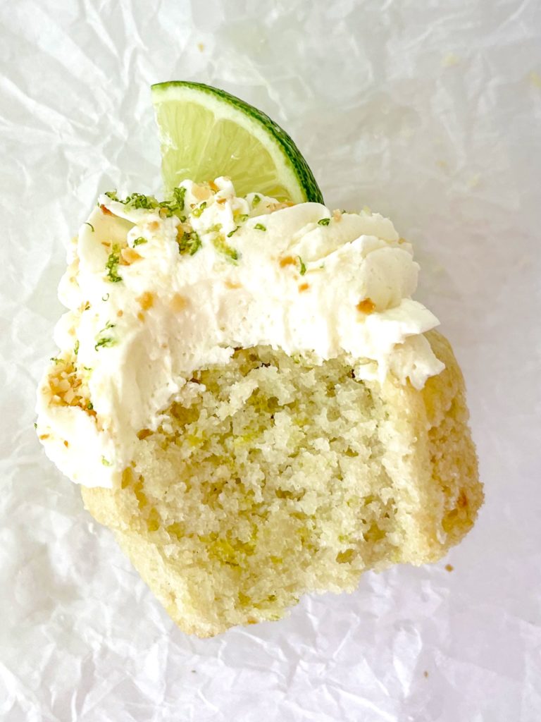 Vegan Coconut Lime Cupcakes close up of one with a bite out of it on its side