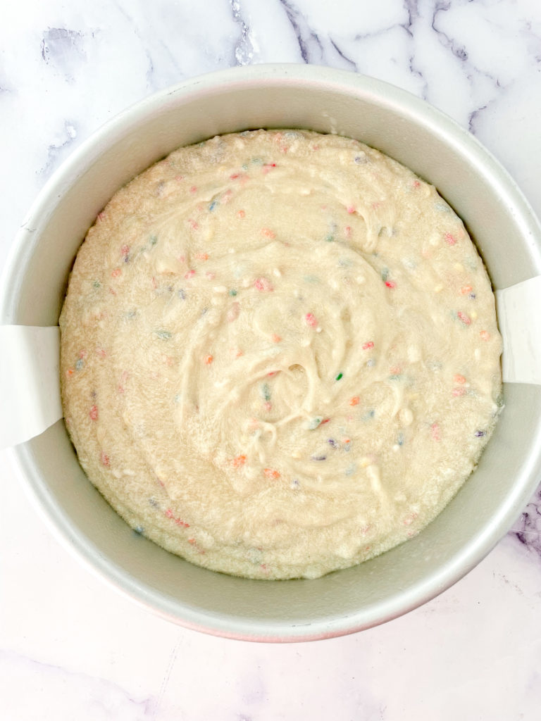 funfetti cake batter unbaked in a cake tin