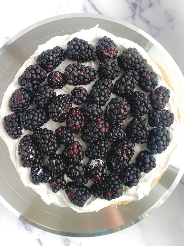 Looking down on a layer of blackberries on top of whipped cream