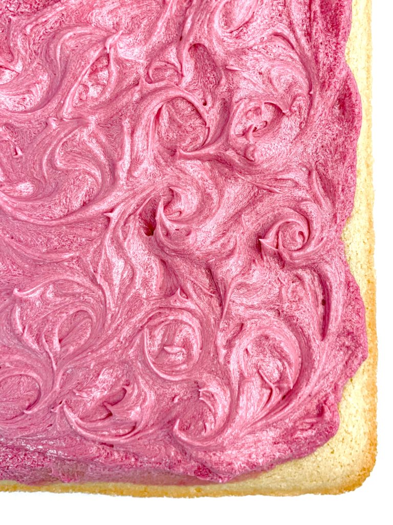 Swirls of pink frosting on top of the completed cake