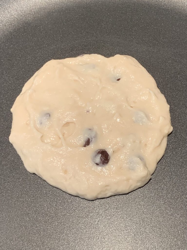 Chocolate chip pancake batter uncooked on the pan