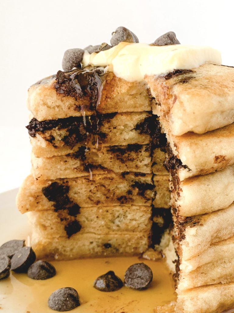 Big stack of chocolate chip pancakes cut into to see the fluffy insides